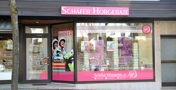 Schaufenster eines Fachgeschäfts für Hörgeräte mit Werbeplakaten und Beratungshinweisen.